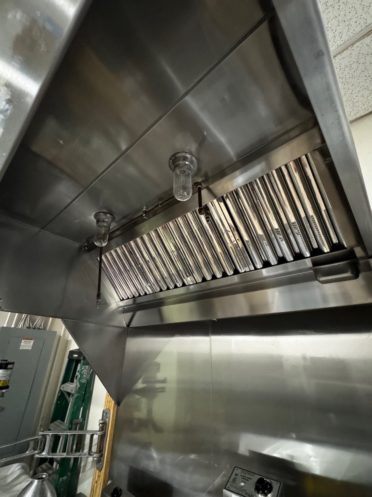 Freshly cleaned stainless steel commercial kitchen exhaust hood